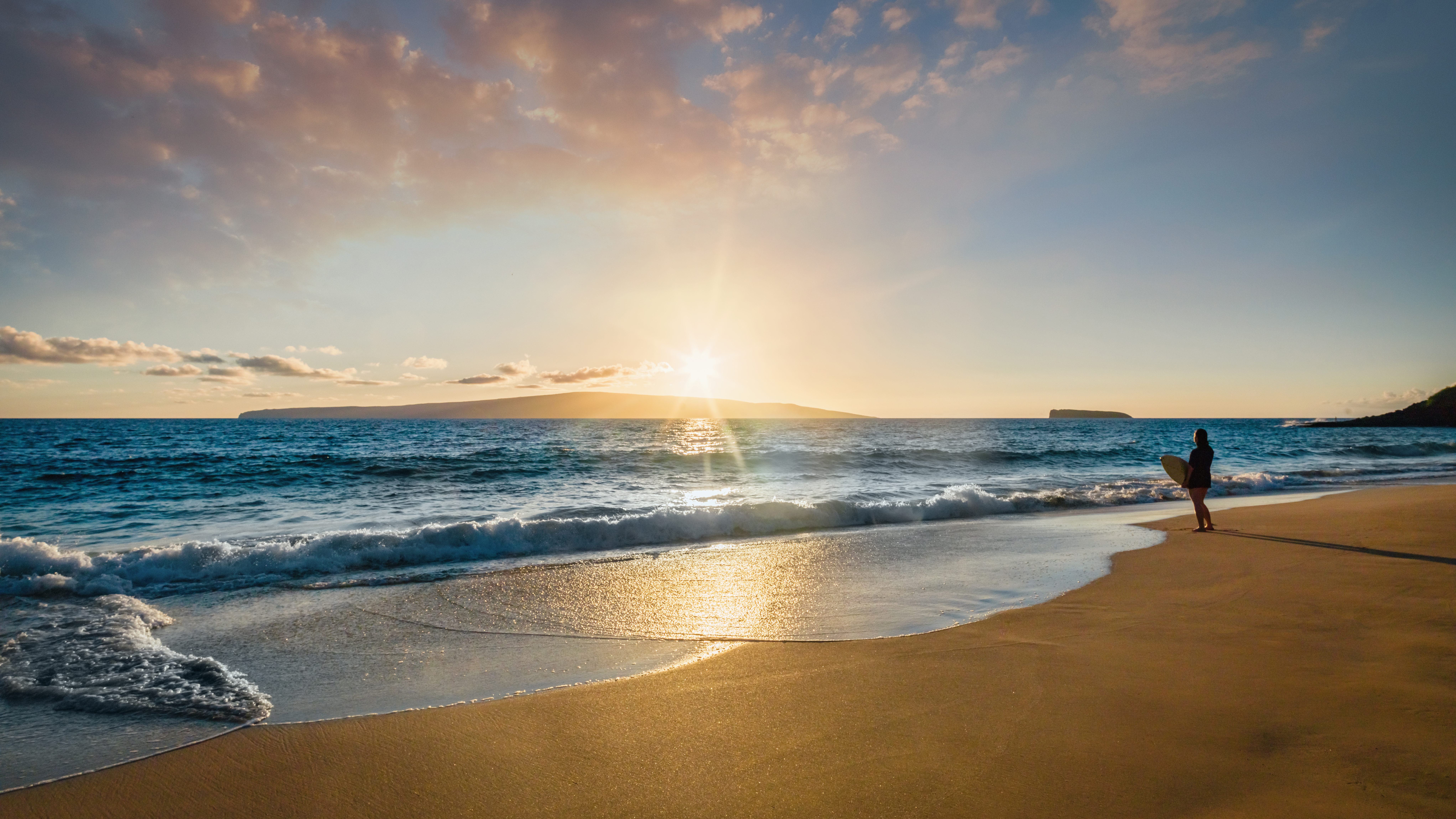 Surfer looking at the waves at sunset