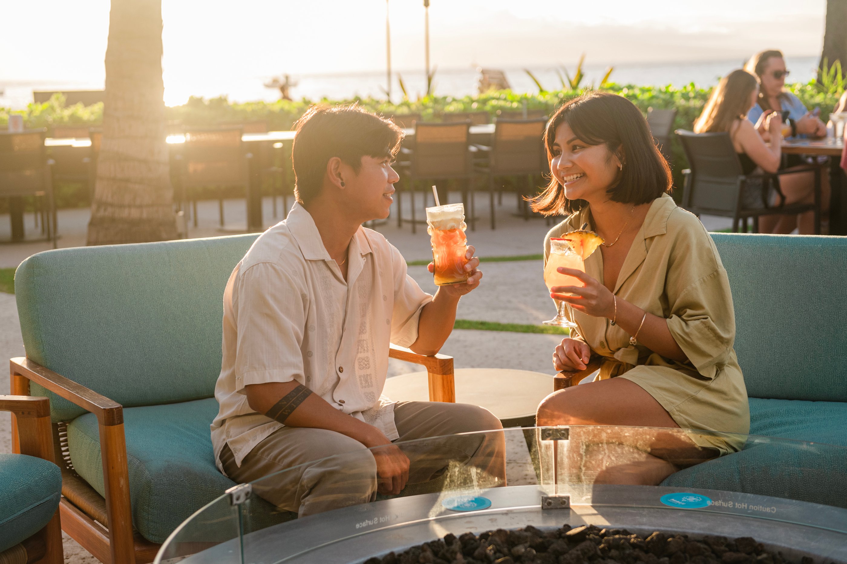 Couple enjoying drinks during sunset at Maui Brew Co. 