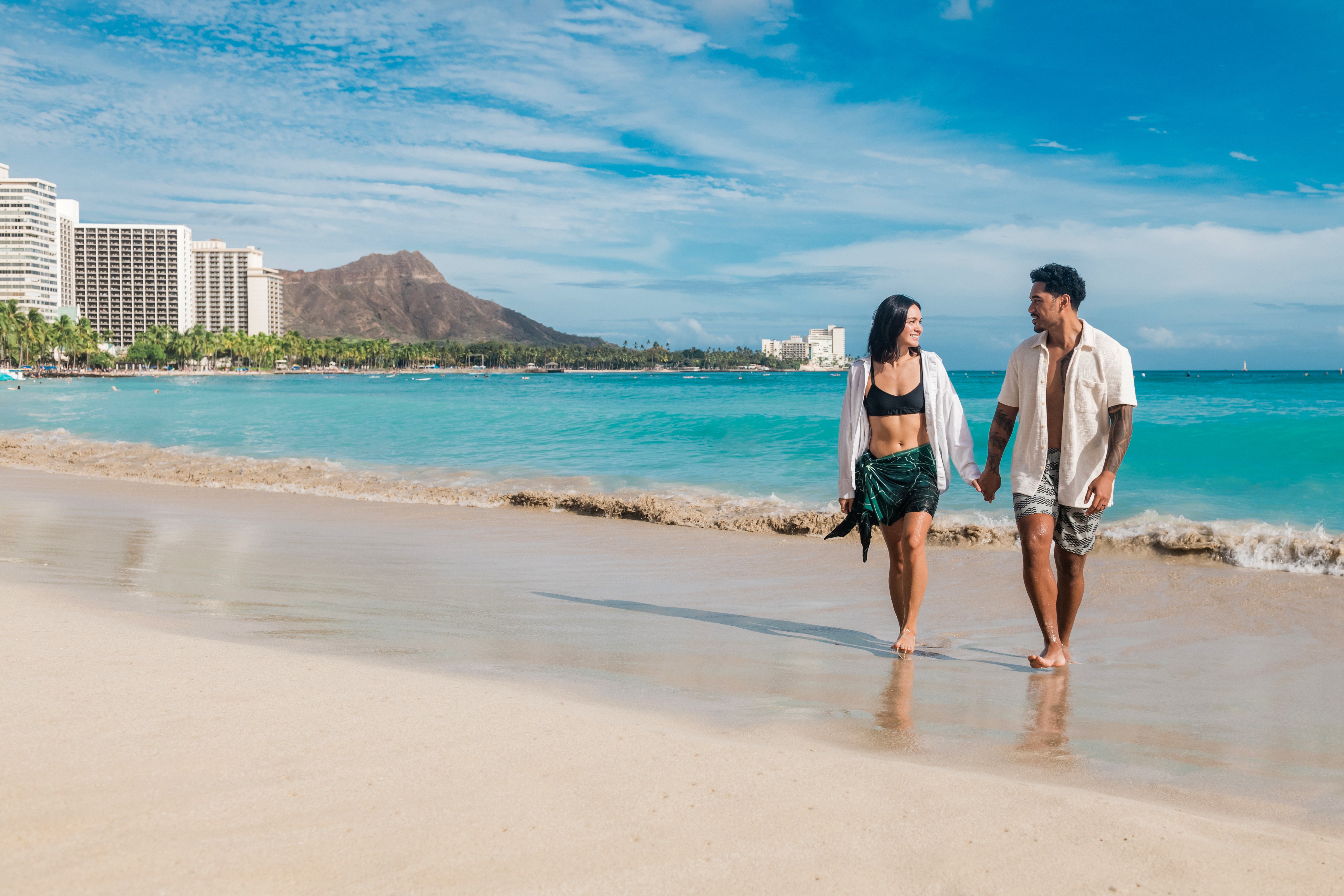Couple walking on the sand on Waikiki Beach